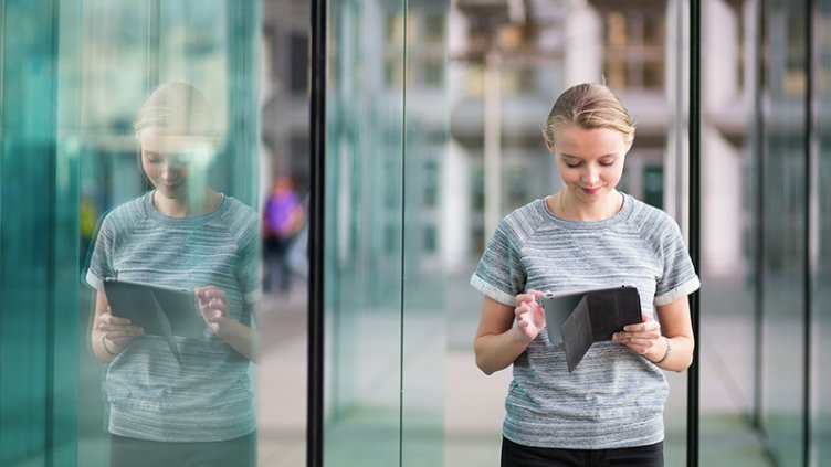 A woman standing and looking at tablet