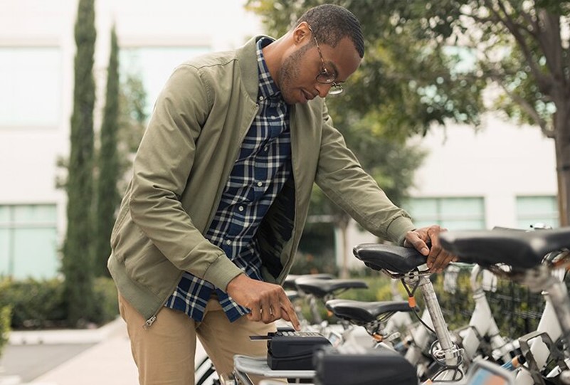 Business people using ride share bicycle outside office building