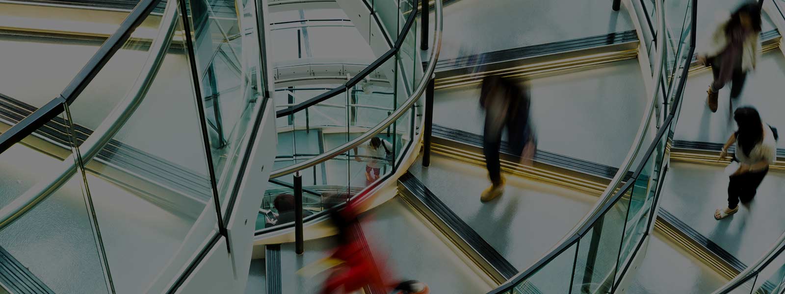 Motion blur of people on a contemporary spiral staircase.